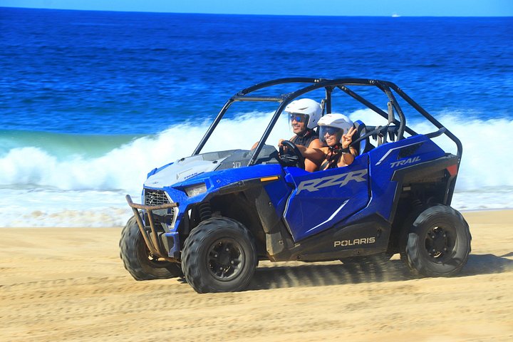 Illustrative two person blue off-road buggy by the coast